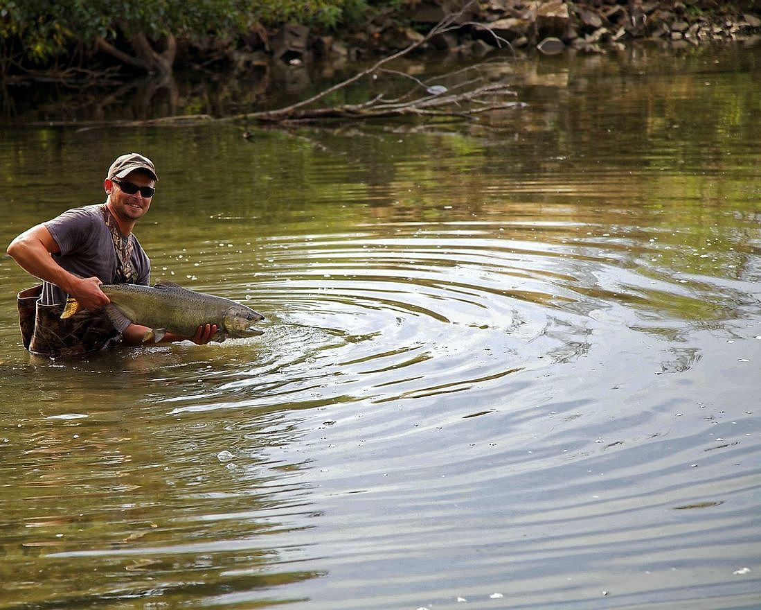 An angler with their catch on the lake